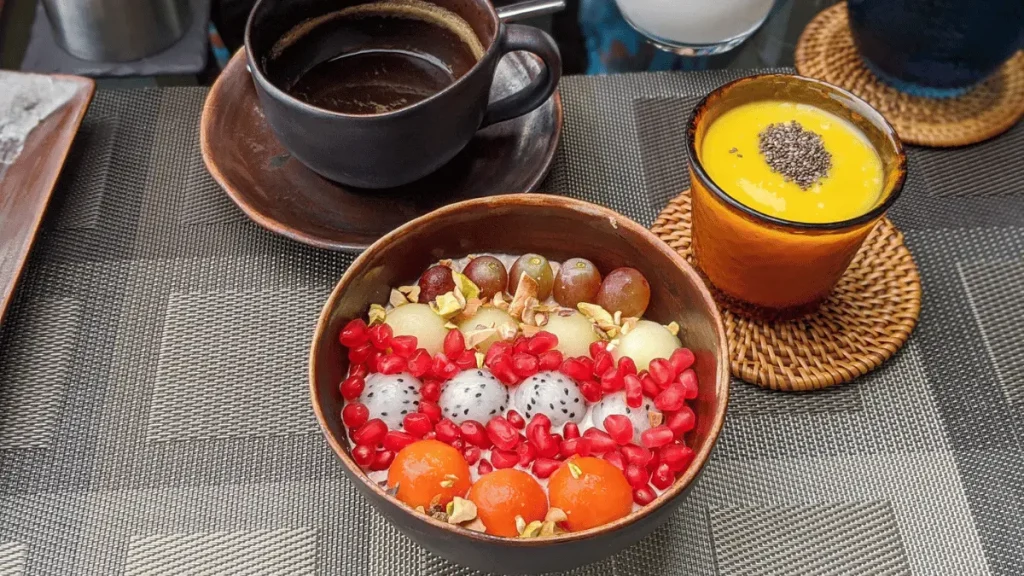 A fruit bowl with a side of mango puree