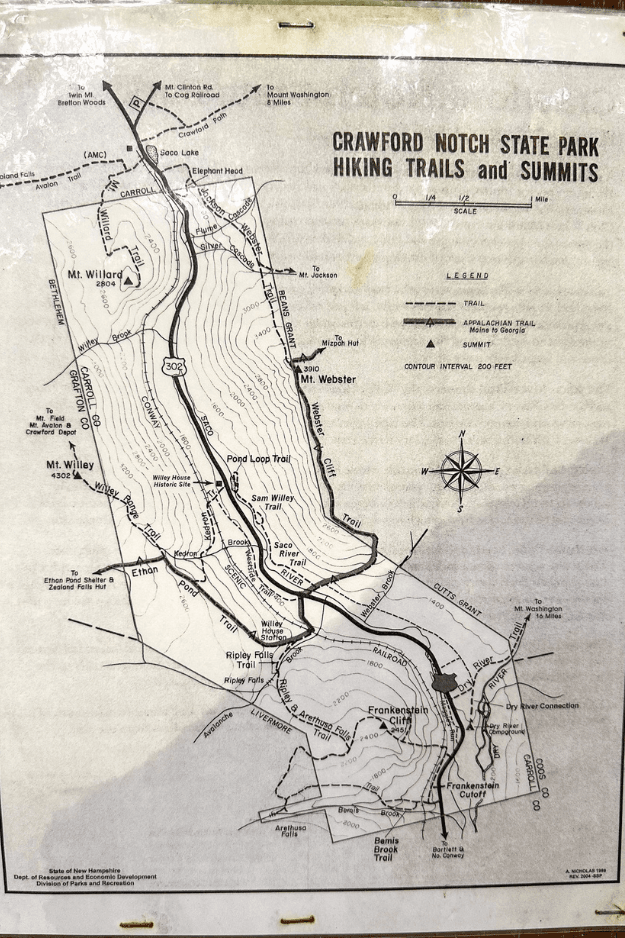 Map of Crawford Notch State Park showing hiking trails and summits including Mt. Willard, Mt. Webster, and Mt. Willey with trailheads, elevation contours, and Appalachian Trail markings. The Mt. Willard Trail is visible leading from Route 302 near the AMC Center to the summit at 2,850 feet.