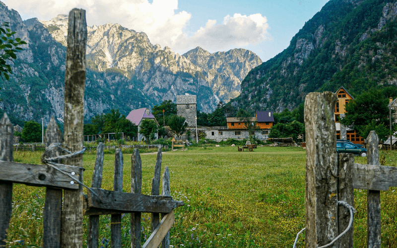The sun sets in Theth Albania with a village in the photo