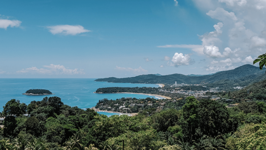 A stunning panoramic view from Karon Viewpoint, overlooking the azure waters of the Andaman Sea and the lush, green headlands near Kata, Phuket.