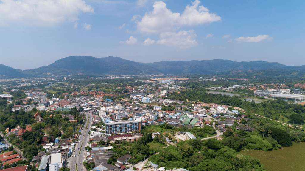 Aerial view of Kathu district in Phuket, showing the dense tropical landscape, residential areas, and surrounding hills.