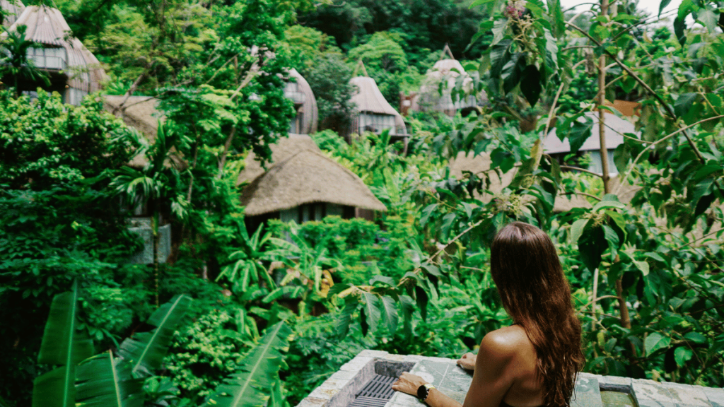 Luxurious Keemala resort in Phuket nestled among lush greenery, with traditional thatched-roof villas peeking through the foliage.