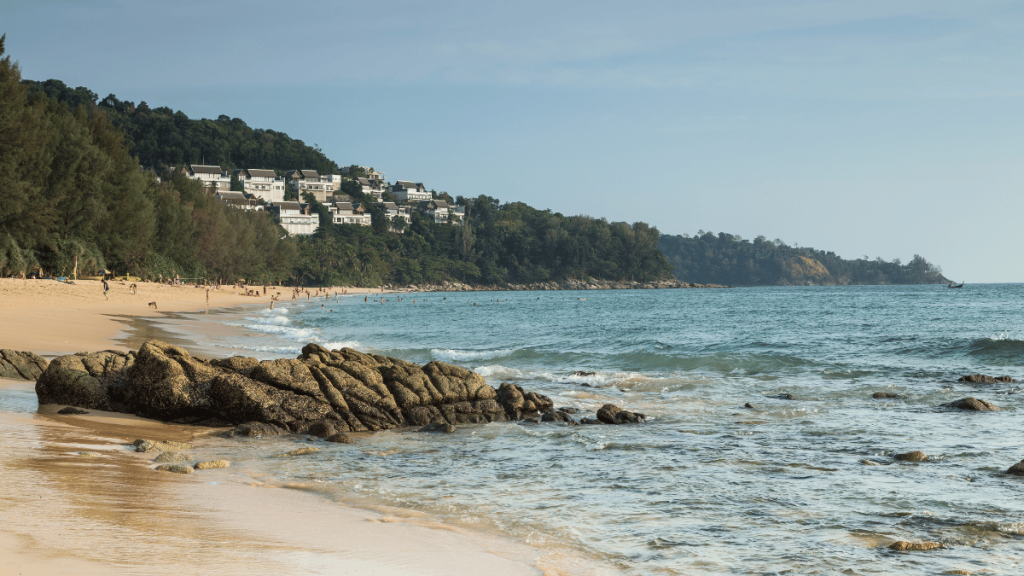 The tranquil waters and golden sands of Nai Thon Beach in Phuket, flanked by lush vegetation