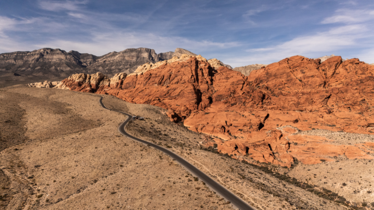 A winding road cuts through the vibrant red rock formations of Red Rock Canyon National Conservation Area near Las Vegas, Nevada.