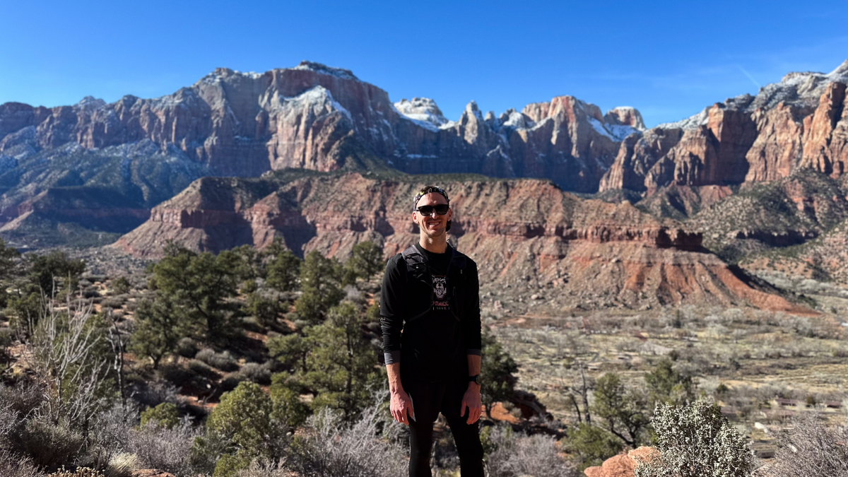 A man stands in Zion National Park in the middle of a run