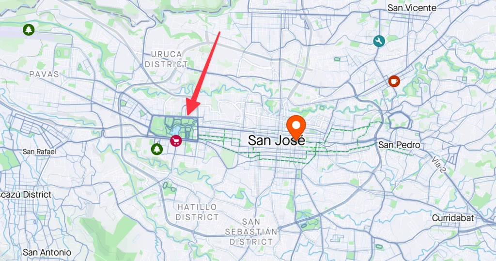  map of San José, Costa Rica, marked with icons for amenities like shopping and parks. A red arrow points to a specific downtown area near the labeled "San José" marker, with surrounding districts like Uruca and Hatillo also labeled.