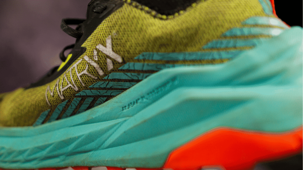 Detailed view of the lateral heel on the Altra Olympus 2.75, showing the textured MATRYX fabric, layered blue design, and part of the cushioned turquoise midsole.