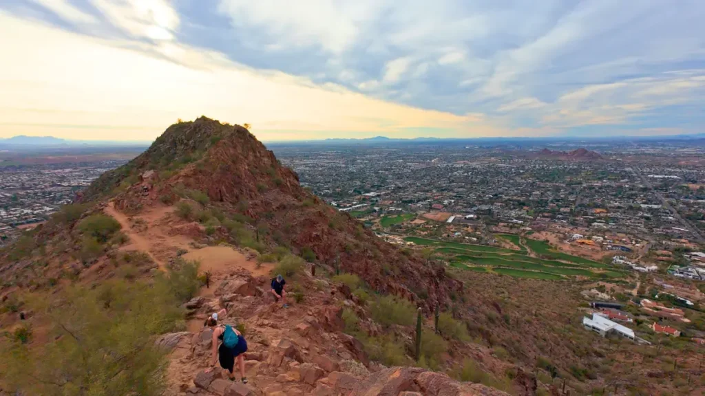 A technical downhill descent on Cholla Trail with views of the ridgeline, showcasing the rugged terrain encountered when running Camelback Mountain.