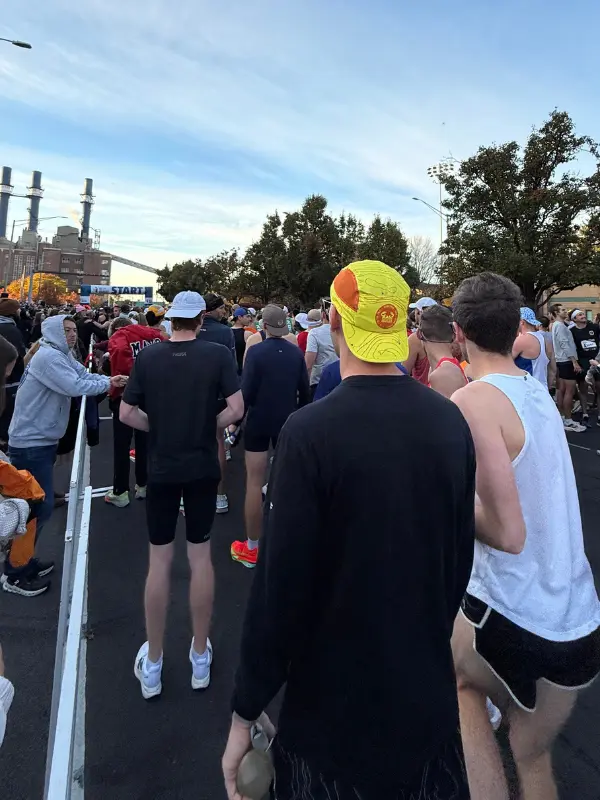 Runners packed into the corral at the Indianapolis Monumental Marathon start line early in the morning, with the START banner visible in the distance