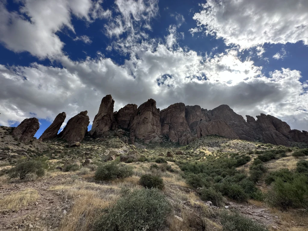 Rock formations along the Treasure Loop Trail in Lost Dutchman State Park under dramatic desert clouds